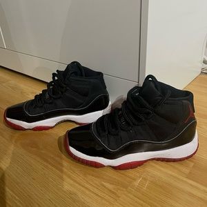 a pair of bred 11s; size: 4.5